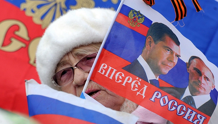 3月17日，克里米亚公投后，塞瓦斯托波尔一名老人挥舞着印有普京和梅德韦杰夫头像的俄罗斯国旗。